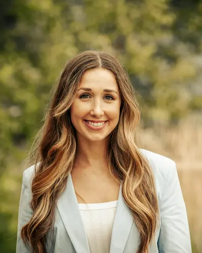 Original photo: a woman with long wavy hair in a light blazer outdoors