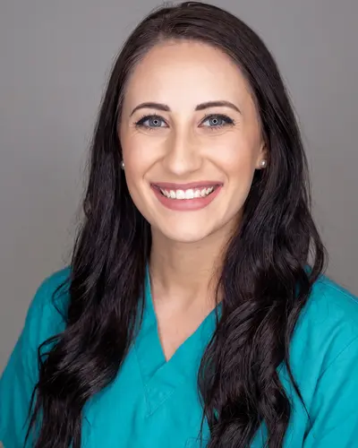 AI example made from that photo: the same woman in teal scrubs on a gray background