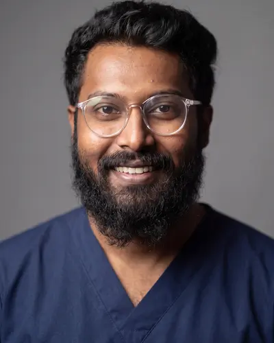 AI example made from that photo: the same man in navy scrubs on a gray background