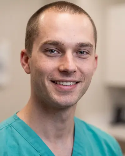 AI example made from that photo: the same man in teal scrubs in a bright room
