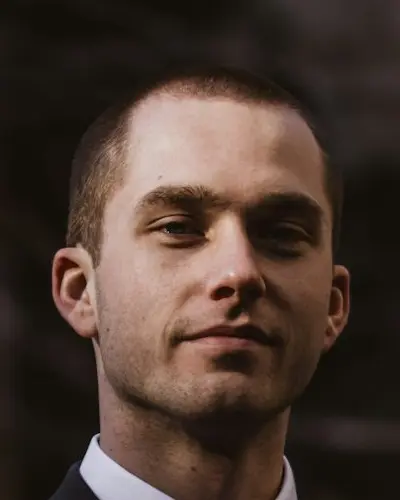 Original photo: a young man in a dark suit outdoors at night