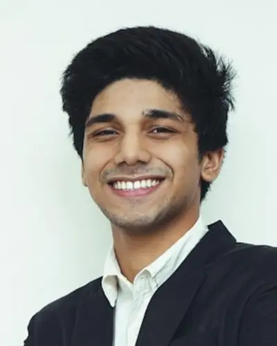 Original photo: a young man in a dark suit against a light wall
