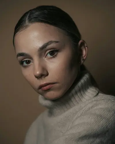 Original photo: a young woman with her hair tied back in a sweater